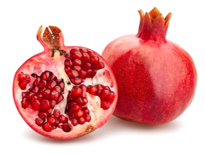 beautiful red pomegranate cut open with a white background